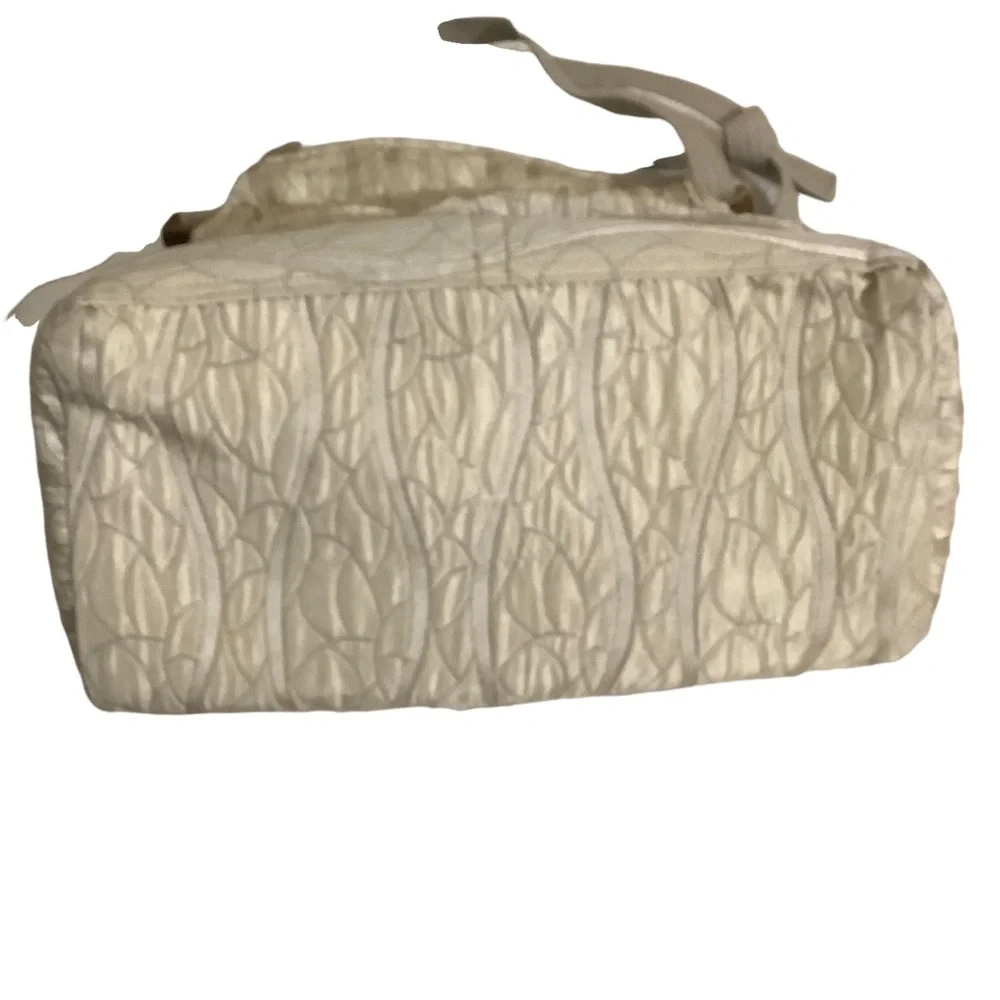FABRIC SHOULDER BAG WITH OUTSIDE SURROUNDING POCKETS IN A CREAM AND TAUPE COLOR.